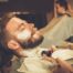 Client during beard shaving in barber shop